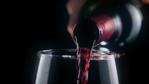 Pouring red wine from a bottle, very close view