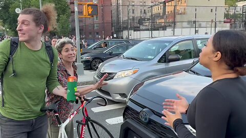 In NYC, two white liberals obstructing traffic, laugh at a black woman attempting to get to her job.