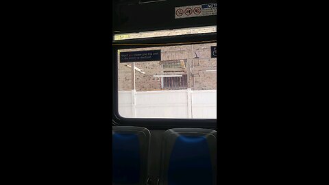 Perp at the bus stop doing hand signals, wearing red.
