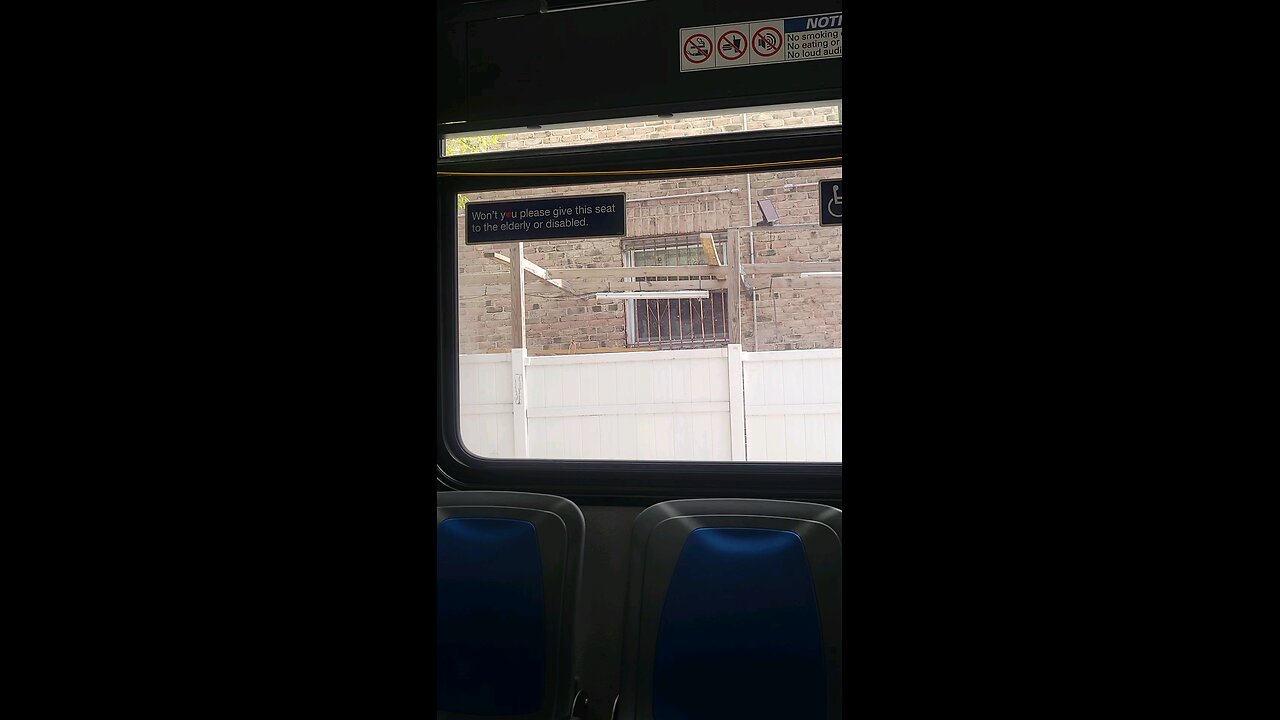 Perp at the bus stop doing hand signals, wearing red.