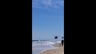 A pair of Boeing CH-47 Chinooks over the beach