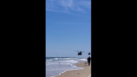 A pair of Boeing CH-47 Chinooks over the beach