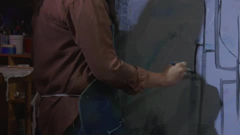 A young woman painting a mesmerizing abstract art piece with a thick brush in her studio