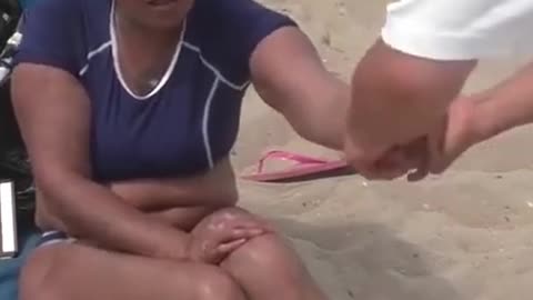 Luodong Treats Hispanic Woman's Forearm On The Beach