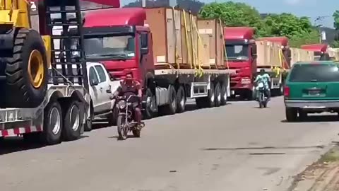 Venezuelan woman excitedly records the arrival of new industrial machinery