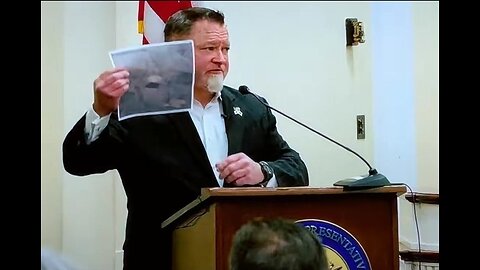 Ex- Pentagon official Luis Elizondo holding a photo of a "Silver Disk UFO"
