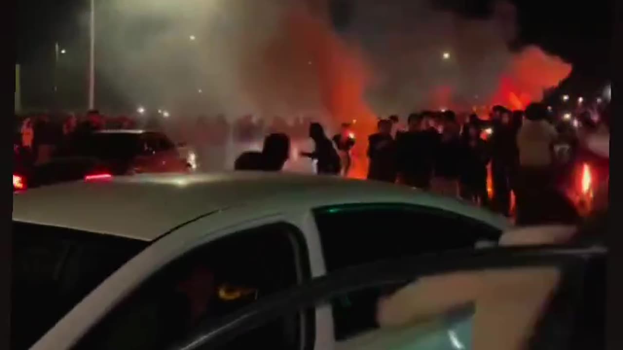 LA rioters surround a car with a mother and her babies.