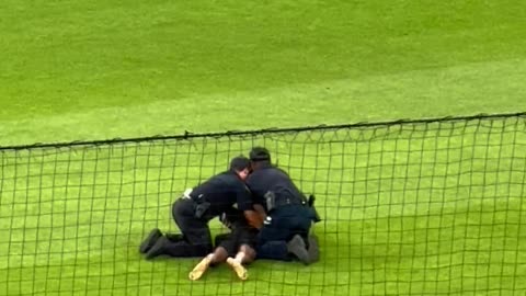 Football Fan Runs on Field at a Baseball Game