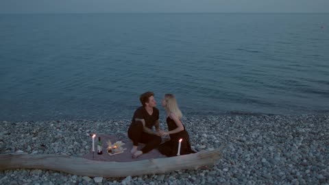 Romantic Couple Kissing Each Other and Having a Dinner Date on Rocky Shore