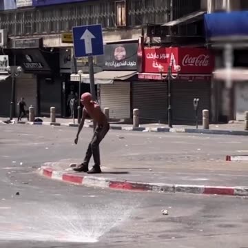 An unarmed Palestinian young man stood defiantly against heavily armed Israeli occupation forces