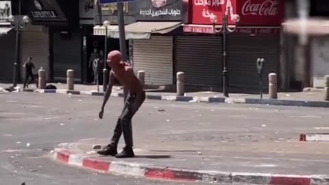An unarmed Palestinian young man stood defiantly against heavily armed Israeli occupation forces