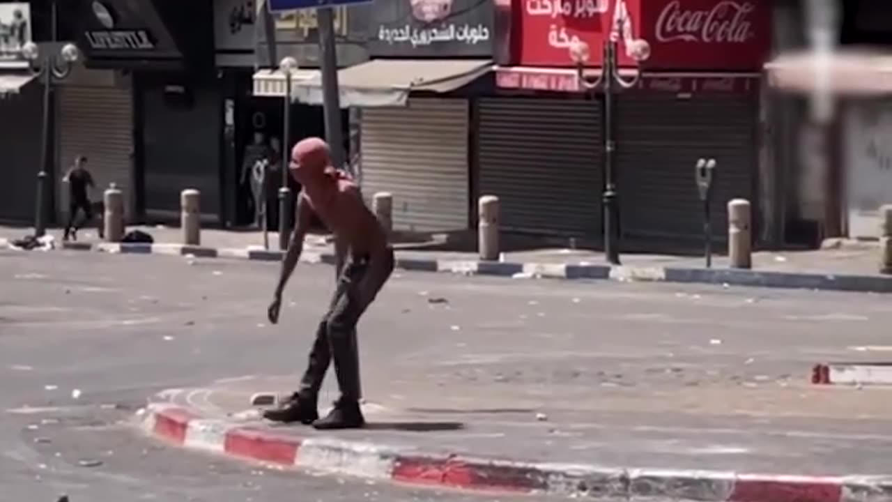 An unarmed Palestinian young man stood defiantly against heavily armed Israeli occupation forces