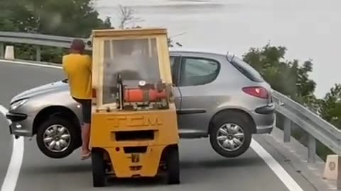 Forklift Carries a Car on the Road