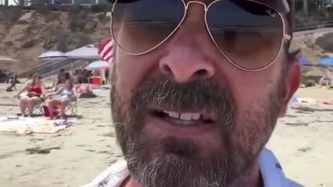 Left wing extremist gets angry upon seeing the American flag on the beach