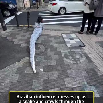 Brazilian influencer dresses up as a snake and crawls through the streets of Japan scaring residents