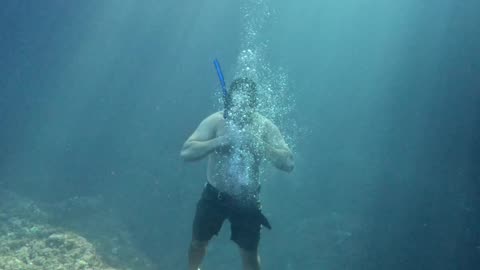 Freediver Blows Bubble Ring From Sea Bottom