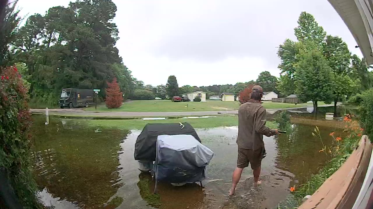 UPS Driver Delivers Heavy Package Through Flooded Yard