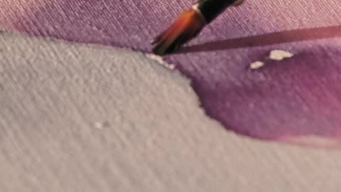 Hands painting a canvas with watercolor