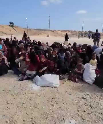 Women from Gaza sit on the floor at the GHF American-Israeli Relief Center in Rafah this morning. They greet security guards. Waiting to receive aid.
