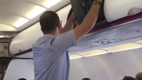 Il essaye de faire rentrer sa valise dans le compartiment