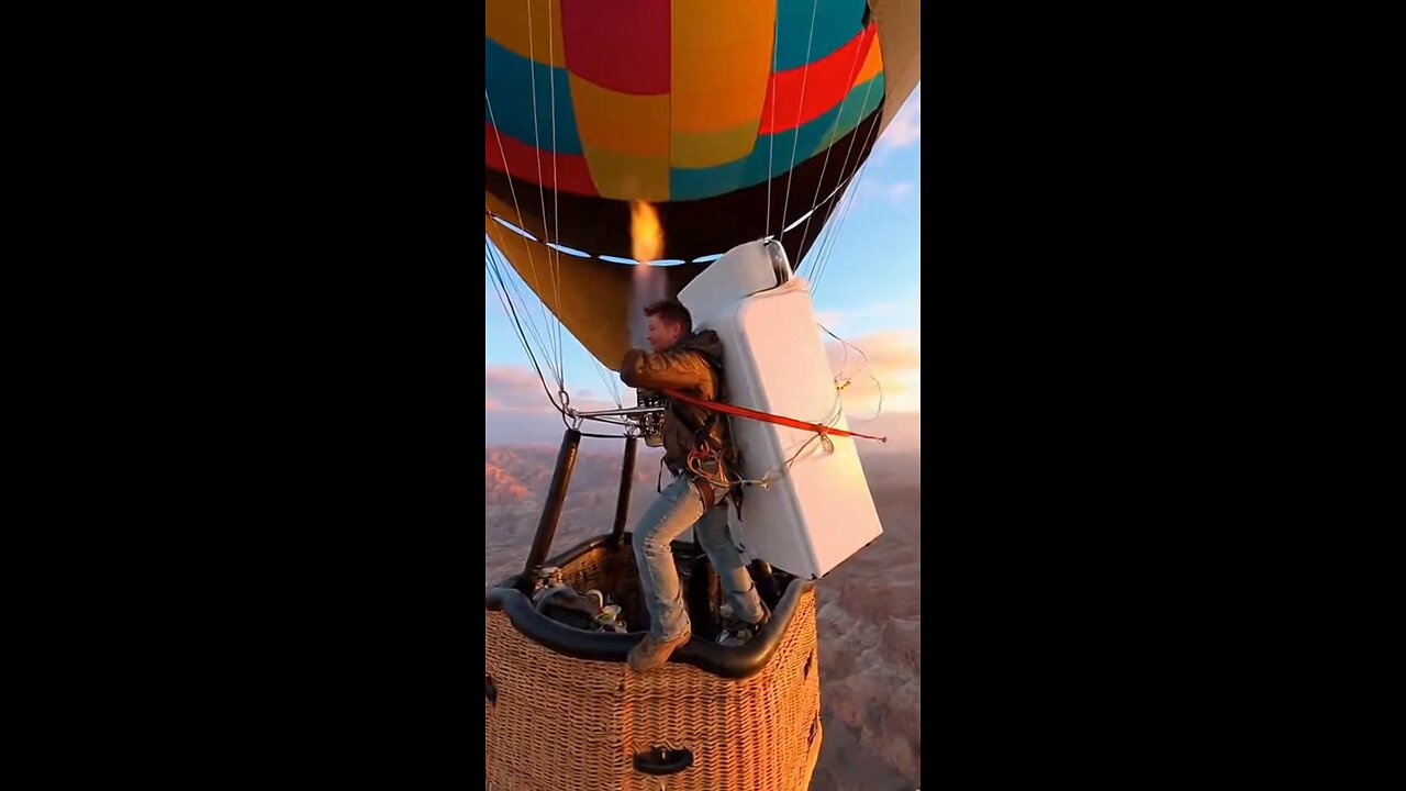 Joseph Martelli with a refrigerator on his back while on a hot air balloon