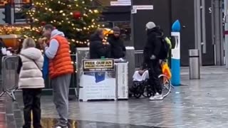 Dishing out free Qurans right next to a Christmas tree.