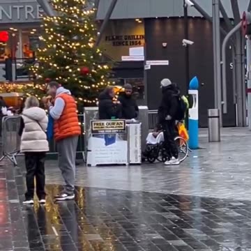 Dishing out free Qurans right next to a Christmas tree.
