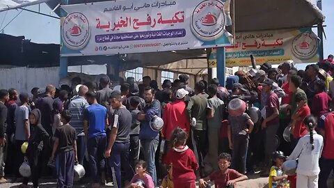 People surge forward to get food at charity kitchen in the Gaza Strip