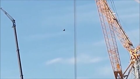 Metallic UFO Hovers over Construction Site