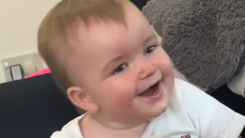 Baby Laughs at His Mom Reading a Book