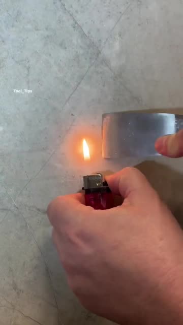 Hand Holding Lighter Heating Metal Blade Close-Up