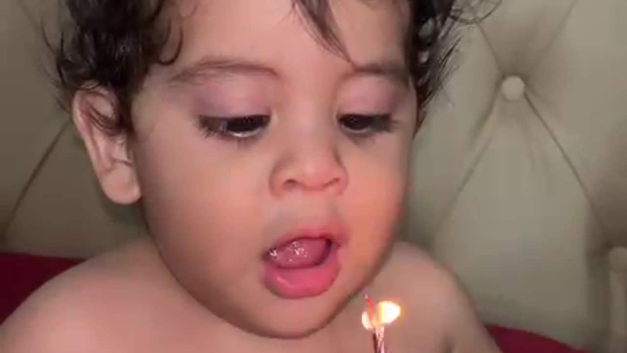 Little Boy Trying His Best to Blow Out Candles