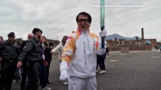 Jackie Chan carries the Olympic Torch through the ruins of Pompeii