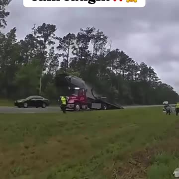 Distracted driver, jumps car over tow truck bed!!!
