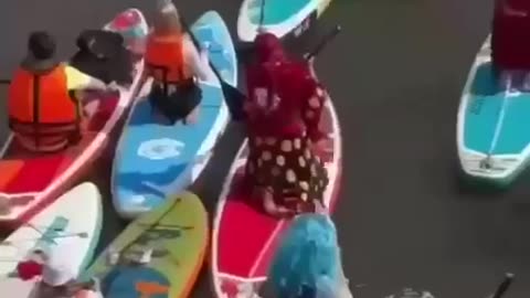 Costumed paddleboarders brighten Moscow River during heatwave