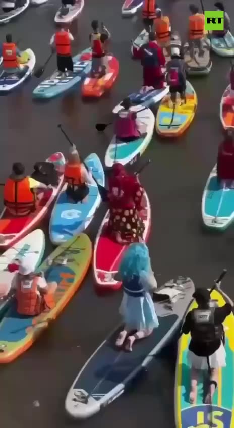 Costumed paddleboarders brighten Moscow River during heatwave