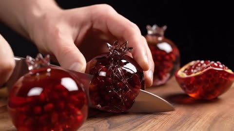 ✨ Watch the perfection unfold as she cuts through a glassy pomegranate with pure precision. 🍷