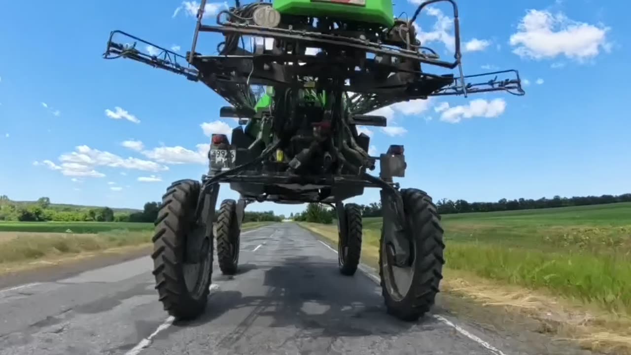 Driving a Motorcycle Under a Field Sprayer
