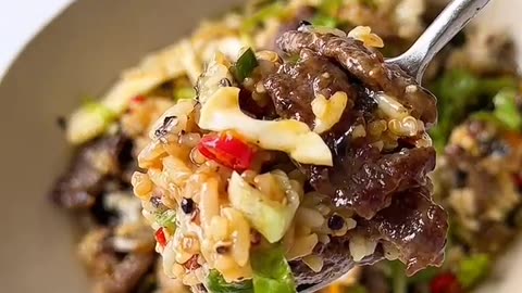 Spicy Beef, eggs with rice and vegetables drizzled with spicy soysauce