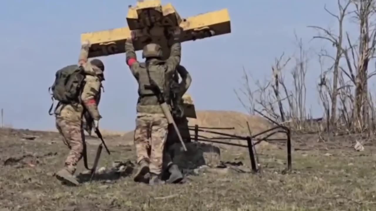 Russian soldiers raise a wooden cross in the liberated Kursk region.