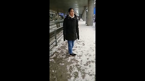 Beautiful young girl freezes while waiting for the bus.