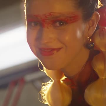 Woman with braided hair and vibrant makeup