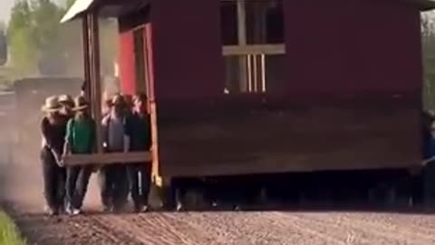 50 Amish men and their kids carrying a small barn
