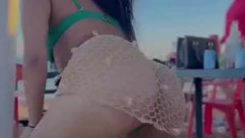 Young girl shakes a large naked ass on the beach