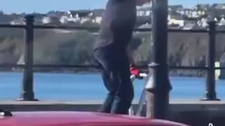 Waterford Anti Irish bigot rips down a an Irish tri colour. He rips it in half.