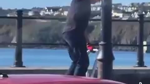 Waterford Anti Irish bigot rips down a an Irish tri colour. He rips it in half.