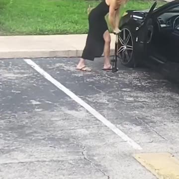 Woman attempts to fill car flat tire with bicycle air pump, try not to laugh