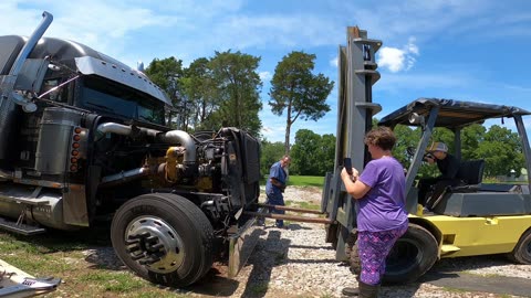 TRUCKER'S WIFE HOLDS UP THE RADIATOR / YOUNG SON OPERATES FORKLIFT
