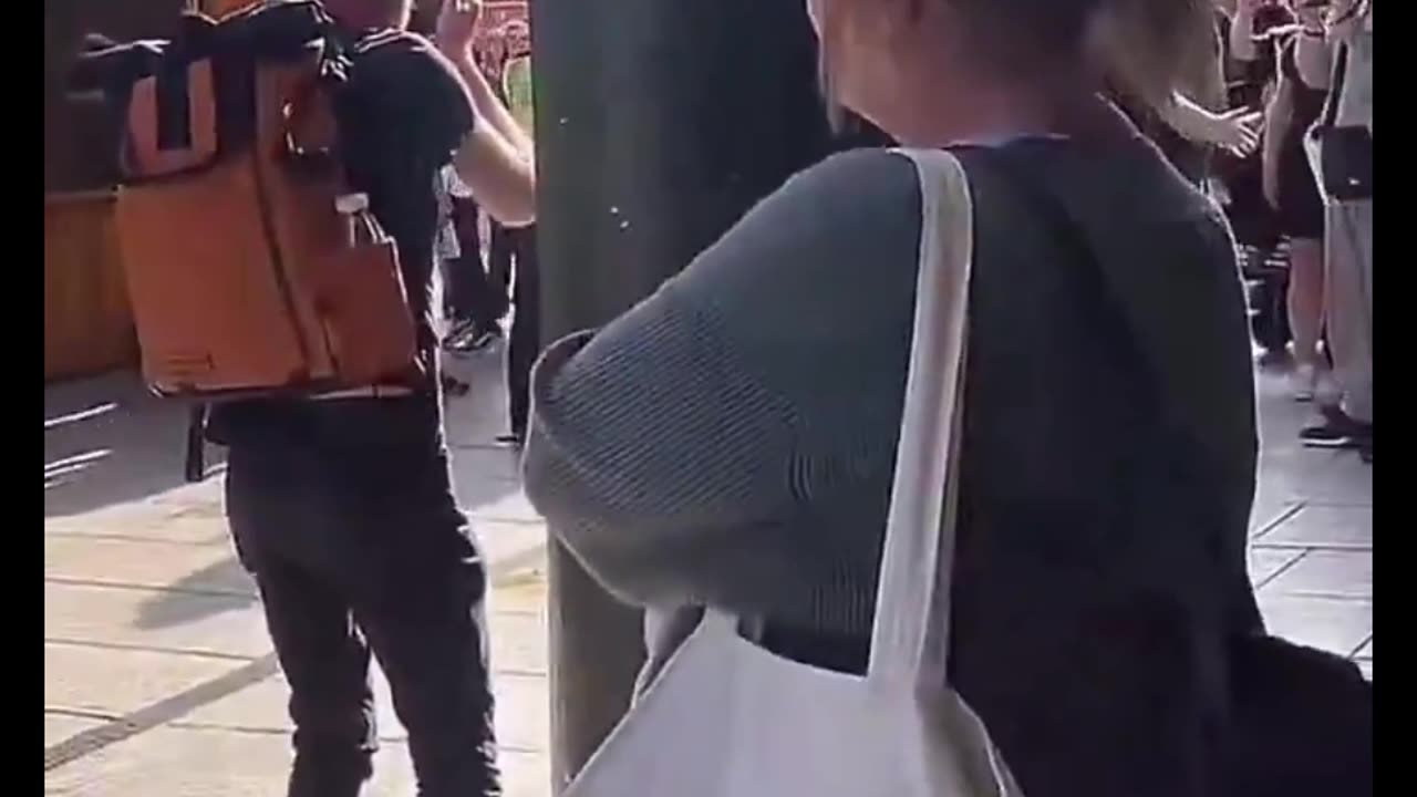 An Asian man is arrested and the crowd start chanting send him back.