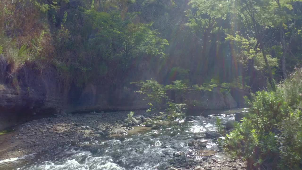 Flying over a relaxing creek full of rock on the countryside